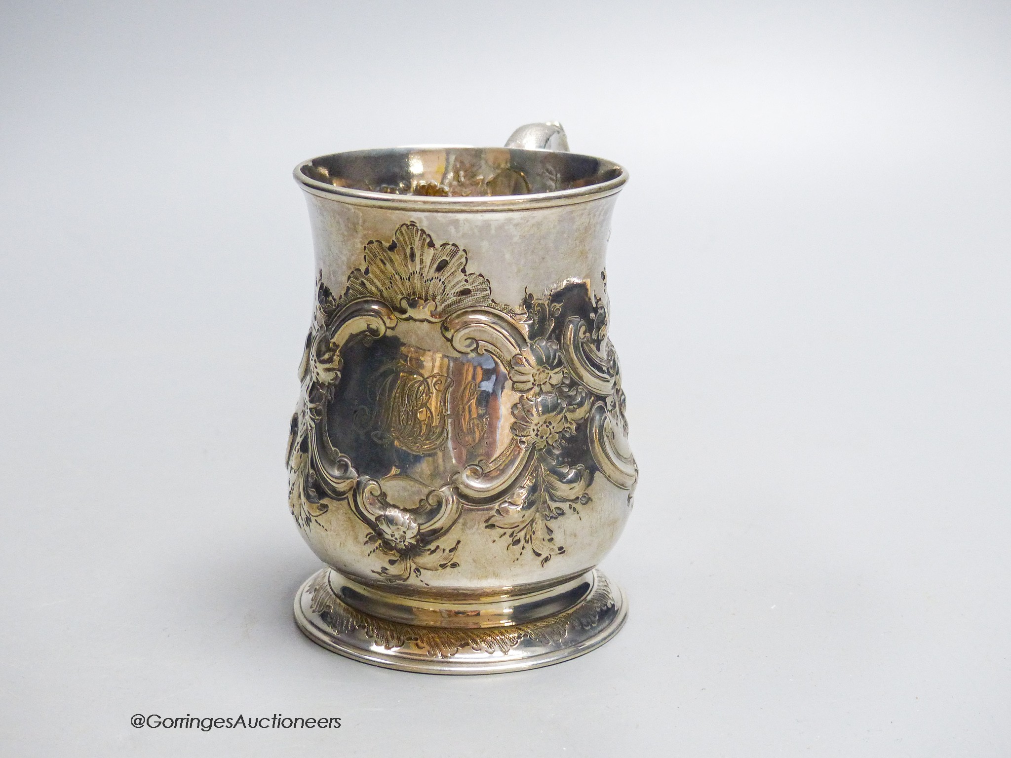 A George II provincial silver baluster mug, with later embossed decoration, James Kirkup, Newcastle, 1751, 10cm, 5.5oz.